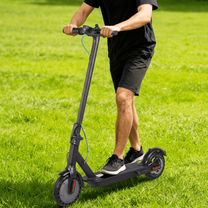 Man riding the SEEDREAM RED WING MINI electric scooter on a grassy field