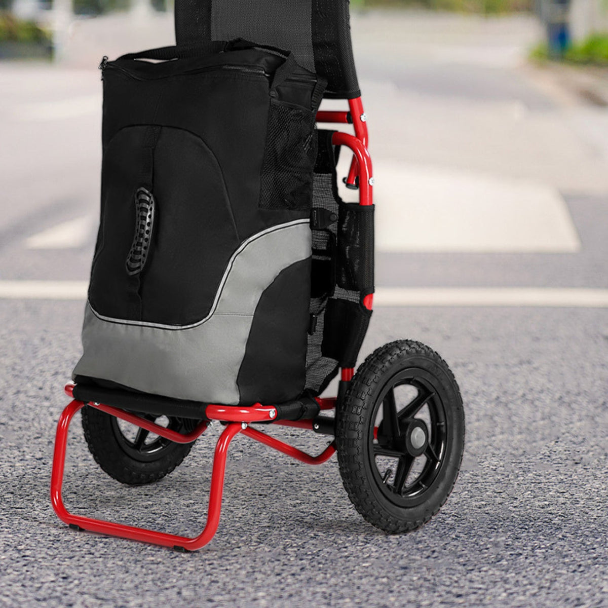 Smart cargo bike trailer in red in hand-cart mode on the street