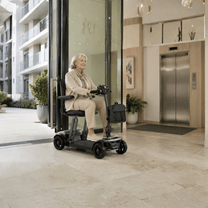 Older woman sitting in the Sweetrich Air Traveller mobility scooter indoors