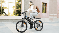 Woman riding the VARUN M24-1 electric mountain bike in black in the city