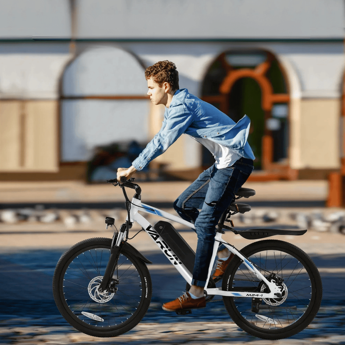 Man riding the VARUN M24-1 electric mountain bike in white in the city