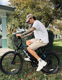 Man riding the VARUN M24-1 electric mountain bike in black in a park