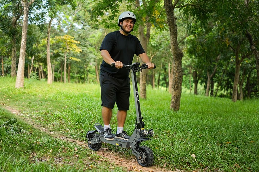Man standing with the VIPCOO VS9 electric scooter in a park