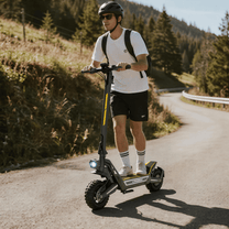 Man riding the Wheely J2 Max electric scooter on a road