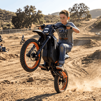 Person riding the Wheely Y88 electric dirt bike on sandy ground
