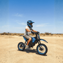 Rider taking the ZAWES S3 electric dirt bike off-road on sandy ground